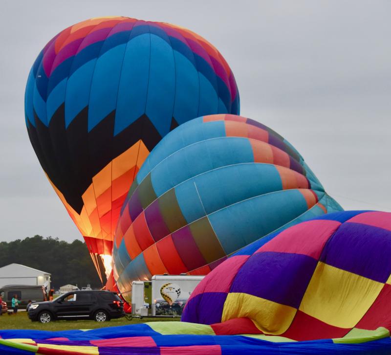 Large hot air balloons begin the process of inflation before takeoff.